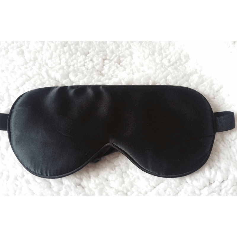 Natural silk sleep mask resting on a cozy wool-textured surface, emphasizing its softness and premium quality.